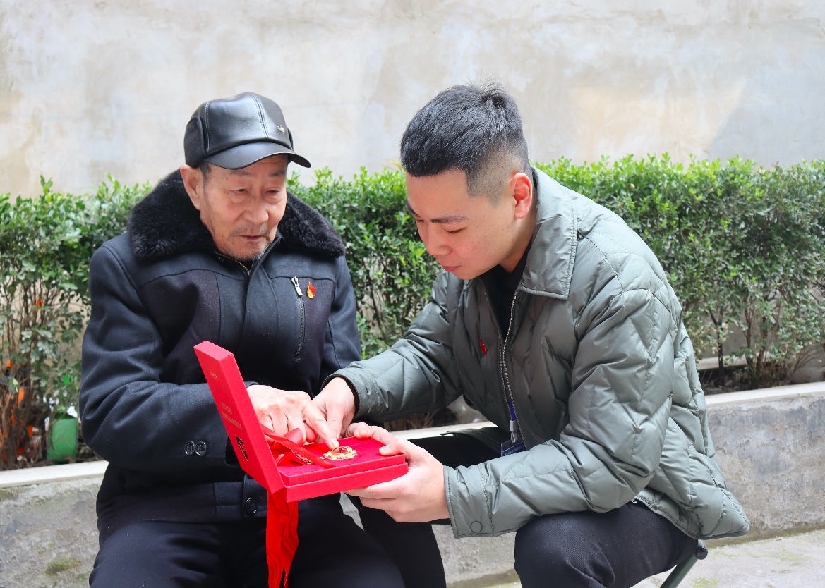 老党员金知一展示“光荣在党50年”纪念章 